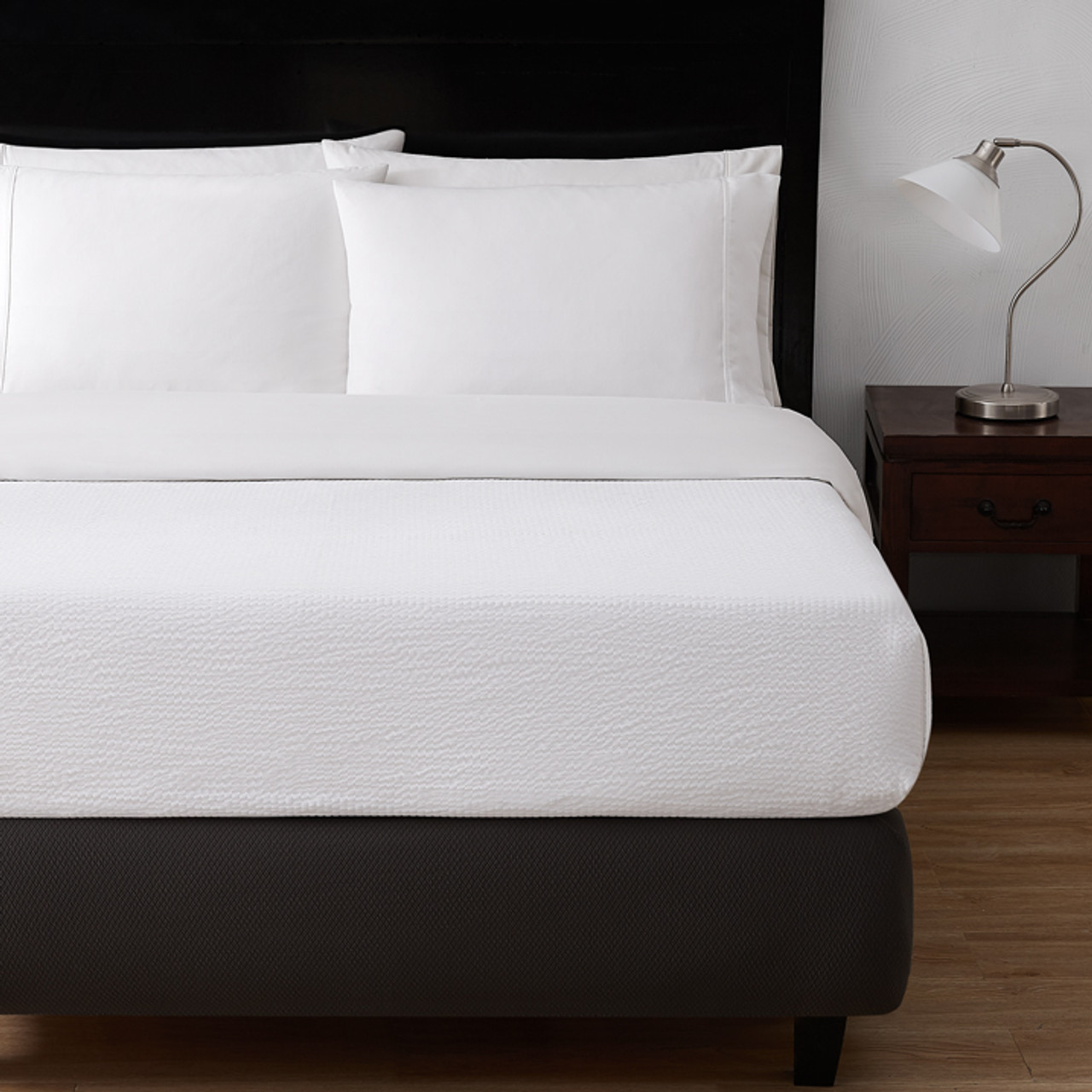Classic Seersucker top sheet on bed with dark wooden accents.