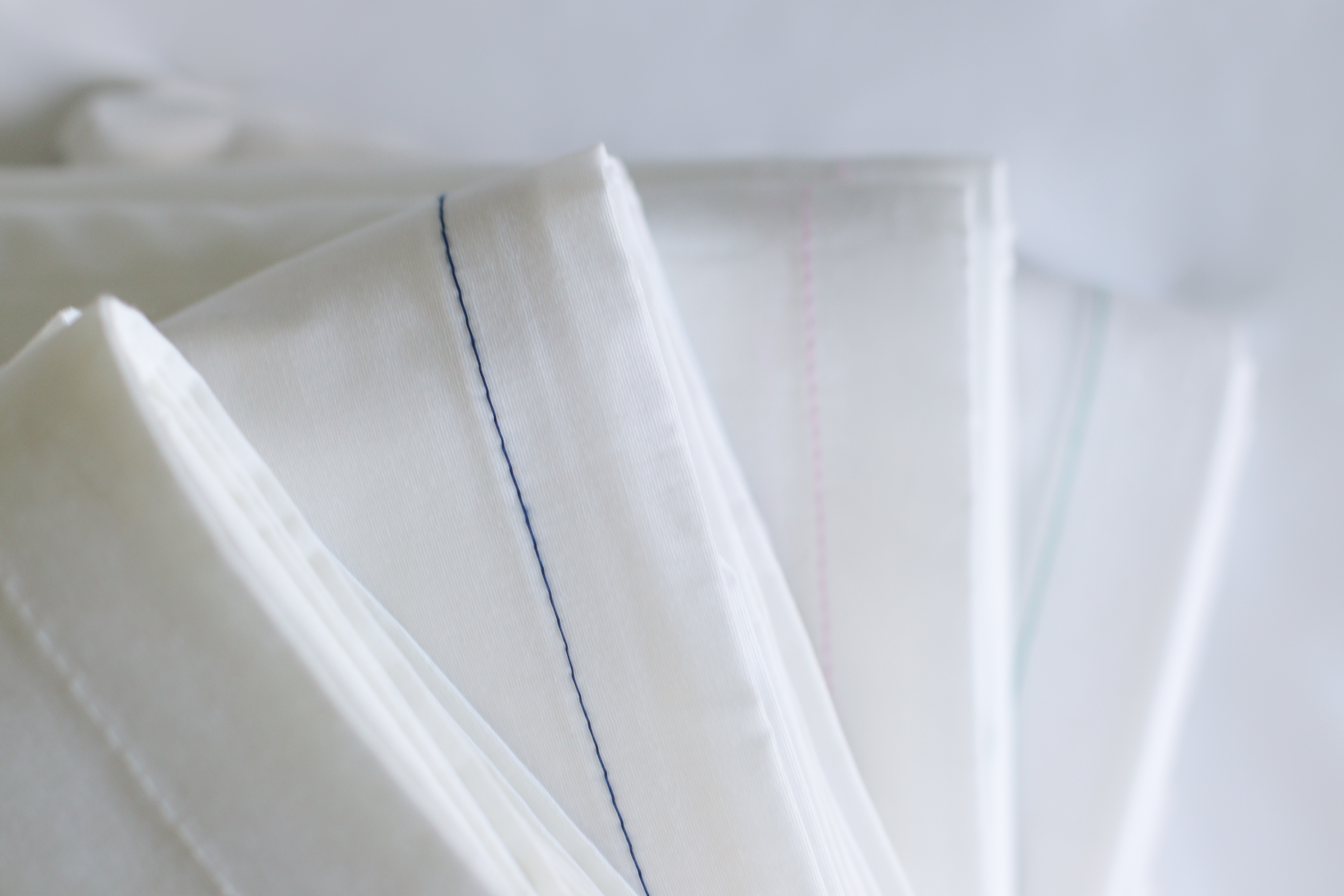 Color-coded hemstitching on folded hospitality sheets