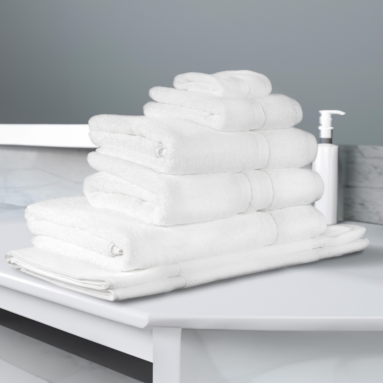 Stack of white towels in a grey bathroom setting.