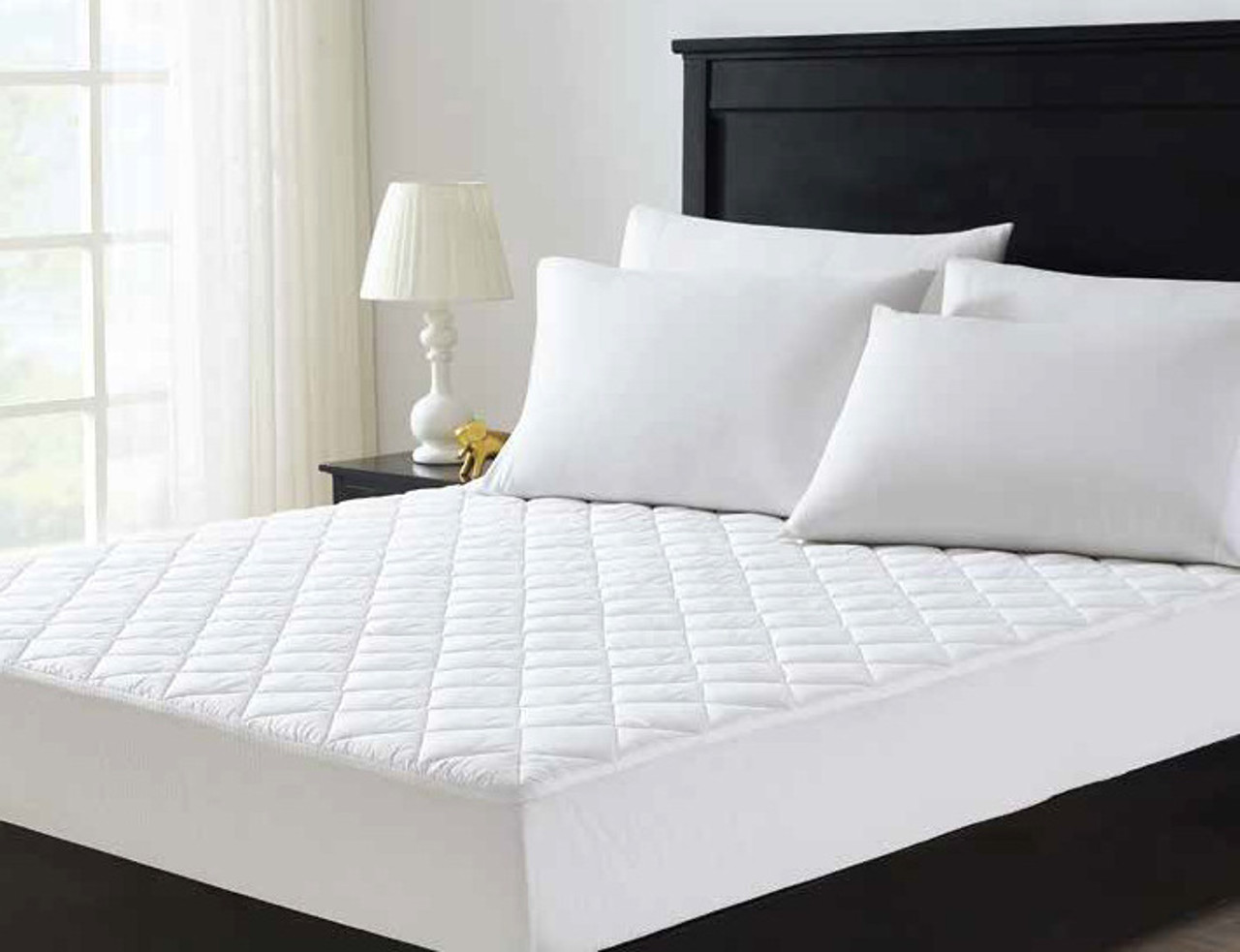 Mattress with Downlite Hospitality waterproof mattress pad with dark wooden accents.